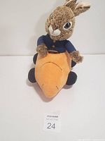 Front view of plush rabbit on carrot vehicle showing details of the rabbit and carrot wheels.