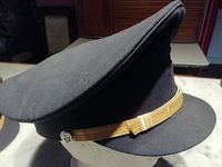 Side view of a black airline pilot captain hat showing the gold band detail.