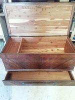 Open view of vintage wooden chest showing large cedar-lined interior compartment and bottom drawer, with chest lid open.