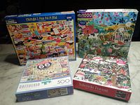 Photo of four puzzle boxes showing their cover images and piece counts.