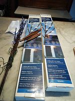 Two boxes of Philips White LED Lawn Stake Branches on a table with some stakes outside the box, some packaging leaflets included.