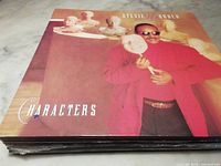 Stevie Wonder 'Characters' album cover featuring Stevie Wonder holding a mask with multiple busts statues around.