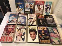Fourteen Elvis Presley VHS tapes arranged in rows, showing colorful original cases in excellent condition.