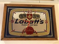 Wooden framed wall clock showing the entire clock face and frame with visible clock mechanism and branding