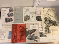 Full layout showing multiple vintage Rolls-Royce airplane engine booklets and technical diagrams spread out on a flat surface.