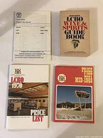 Top-down view of all four LCBO books arranged flat. Includes 'John Reid's LCBO Wine & Spirits Guide Book', and three price lists with covers from 1968, 1970, and 1979.