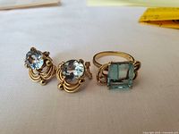 Ring and pair of earrings displayed together on white cloth