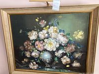 Framed floral oil painting full-view showing gold-tone wooden frame and built-in light bar