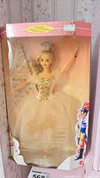 Full view of the Sugar Plum Fairy Barbie Doll in its original box with packaging visible and Nutcracker themed background.