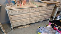 Front view of the Baronet dresser showing six drawers with decorative handles and gold trim.