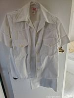 White safari style short-sleeve jacket with button front and flap pockets