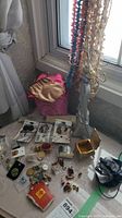 Photo showing necklace holder with multiple hanging pearl and bead necklaces and assortment of pins and small boxes on table