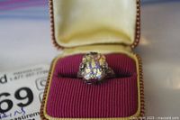 Close-up of the sterling silver ring with oval colorful stone in red velvet box showing the ring details and setting.