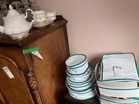 Overall view of teapot, sugar bowl, soup bowls and packing bags in background