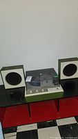 Full view of vintage GE stereo phonograph model P352 and two box speakers on black surface.