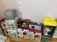 Photo showing multiple stacked boxes of different glassware sets including Fifth Avenue Ltd. crystal goblets, and Mayfair & Jackson shrimp cocktail bowls.