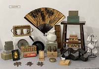 Full lot arranged showing all included items: mugs, mug tree, fan, McCoy pitcher, boxes, wok, dominoes, Foo dogs, stools, cheese spreaders, baskets with fruit, metal box, and decorative pieces.