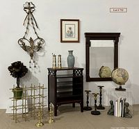 Full shot of the lot showing brass candlesticks, framed floral art, dark wood table, bookends, globe and other decor items.