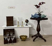 Overview photo showing entire lot with candlesticks, bowl, table, orchid, wine glasses, photo box, jewelry box, vase, globe, ceramic fish.