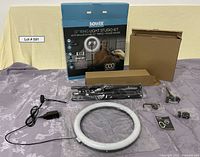 All components of the Bower 12-inch ring light studio kit laid out: ring light, tripod, phone holder, remote control, power adapter, packaging boxes, and cables.