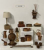 Full lot of copper accessories, lamps, wooden chest and shelf, candlesticks, arranged on white display blocks.