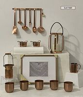 Complete lot arranged on white pedestal, showing all items including hanging utensils, herb pots, lantern, serving pans and framed artwork.