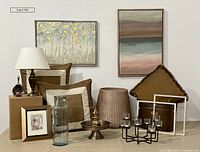 Photo showing full assortment of items including lamp with shade, large basket, two large framed artworks, three large pillows, metal bin, metal frames, framed artwork by R.C. Gorman, cake stand, tea light candle ring and large glass vase.