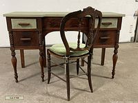 Vintage country French desk / vanity with sage green painted top, dark espresso wood finish, turned legs, and combination of drawers and lined baskets. Matching vintage wooden chair with green cushion in front.