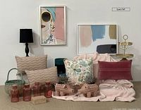 Wide photo showing entire lot with framed artworks, pillows, planters, jars, tray, basket, necklace, lamp, and throw blanket