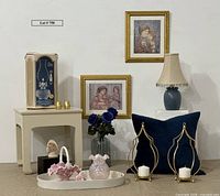 Overall lot view with all glass items, litographs, table, lamp, candles, pillow and accessories arranged