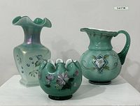 Three-piece set of Fenton glass - pitcher, vase, and bowl, shown together on white surface.