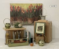 Wide shot of the full lot showing large canvas tulip artwork, wooden garden trug, metal watering cans, wire baskets, books, glass vase with candle, and terra cotta flower frog.