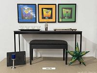 Overall shot showing metal frame table with wooden top, upholstered bench, triptych martini artwork, cocktail shaker, charcuterie boards, metal tray with acrylic glasses, candle holder with candle, and decorative paper star on floor.