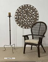 Photo showing the large wall art, rattan chair with cushion, and metal candle holder with candle in a studio setting