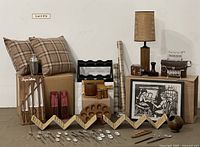 Photo showing the full lot displaying pillows, framed artwork, utensils, and decorative kitchen items.