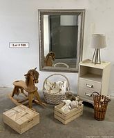 Photo capturing entire lot of assorted neutral baby items including mirror, nightstand with lamp, baskets with toys, rocking horse, and hardwood blocks crate.