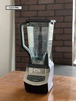 Front side view of Ninja professional blender fully assembled on wooden table.