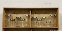 Set of 10 clear glass canisters arranged on wooden shelf, showing varying heights and sizes with silver screw-on lids.