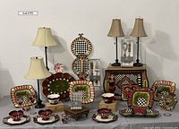 Full display of Amber Rose collection including bowls, plates, lamps, candle holders, serving trays, wooden boxes and metal plate display stand.