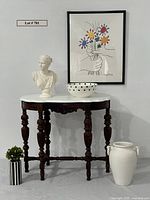 Full view of the antique table with marble top, bust, vases, and framed Picasso print on wall.