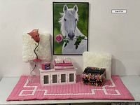 Full lot display on pink and white twin bedspread including the lamp, pillows, storage shelf, acrylic box, candle making kit, and decorative bordette with framed horse poster behind.