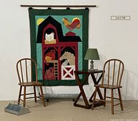 Group photo showing handmade barn animal quilt hanging on wall with pair of wooden children's chairs flanking a small wooden X side table topped with a small lamp with green shade, and two galvanized metal trays/planters placed in front.