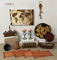 Full lot display including spices of the world canvas, baskets with cork topped bottles, terra cotta tagine, trays, candle holders, woven place mats, wooden bowl, gathering basket, and brass bells