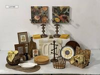Overview of entire lot showing dishes, cutting board, baskets, artwork, sconces, placemats, sunflower plate, and other decorative kitchen items