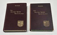 Two hardcover volumes with maroon covers and gold embossing titles and crest. Volume two housed in a protective slipcase.
