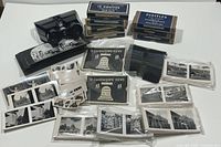 Overall lot: stereo viewer at top left, stacks of boxed film positives behind, loose stereoview cards in front