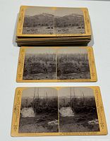 Three stacks of yellow-mount stereoview cards; top cards show forested hillside and smoke-filled battlefield scenes.