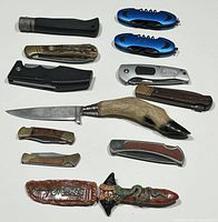 Lot of 10 knives arranged showing variety of folding and fixed blades, decorative handles including animal hoof.