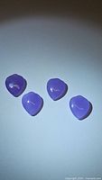Four lavender jade spade-cut gemstones arranged on white background showing color and polish.