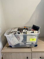 Clear plastic bin filled with multiple packages of pantyhose and tights including visible brand names and labels.